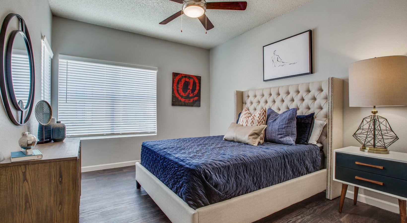 a bedroom with a bed, dresser and ceiling fan at The Felix