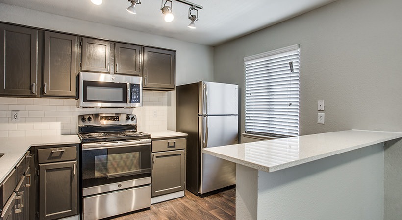a kitchen with stainless steel appliances and wood floors at The Felix