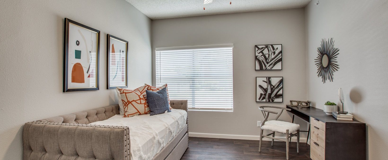 a bedroom with a bed, desk and ceiling fan at The Felix