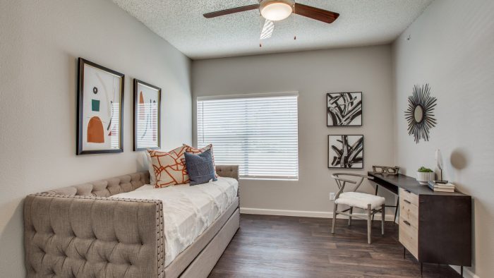 a bedroom with a bed, desk and ceiling fan at The Felix